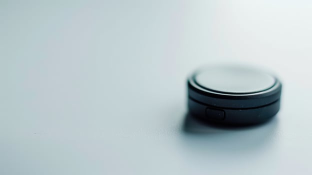 Tiny black gps tracker rests on a white background, poised to offer location data photo