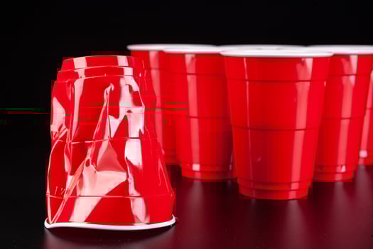 Red plastic cups and ball for game of beer pong photo