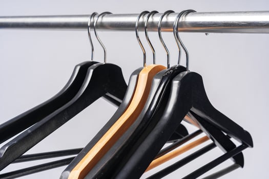 Metal rack with clothes hangers on grey background photo