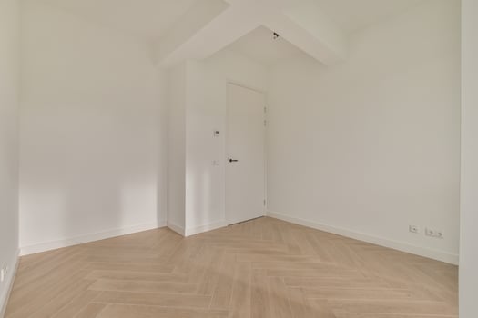 An empty room with white walls and wooden floors photo