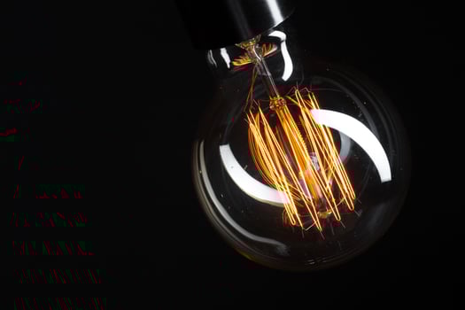 A classic Edison light bulb on dark background with space for text photo