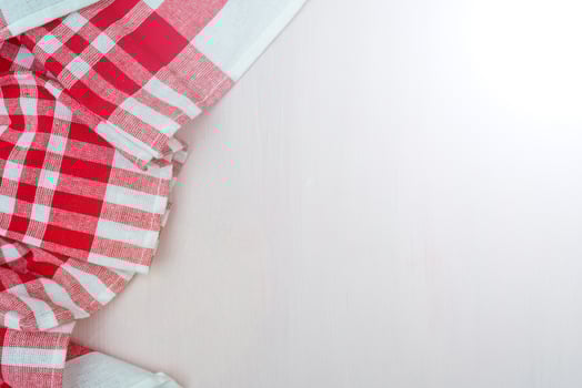 Red checkered towel on the kitchen table. Wooden table background. photo
