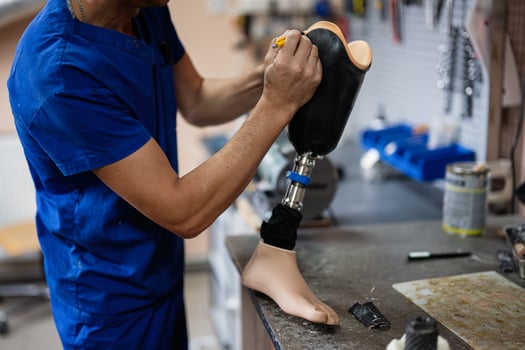 Technician crafting a prosthetic leg in workshop setting photo
