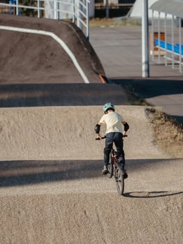 Boy or young rider on BMX Race made from soil and sand. Adrenaline-Pumping Dirt BMX Race Track. Extreme sport and bicycling concept photo