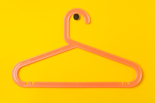 Hanger on colored paper background. Minimalistic fashion concept. photo