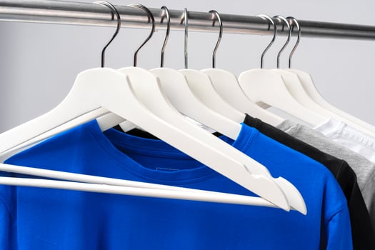 Clothes hang on clothing rack over white background. photo