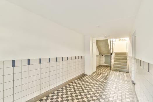 A hallway with a tiled floor and stairs photo