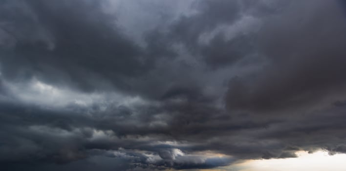 The dark sky with heavy clouds converging and a violent storm before the rain.Bad or moody weather sky and environment. carbon dioxide emissions, greenhouse effect, global warming, climate change. photo
