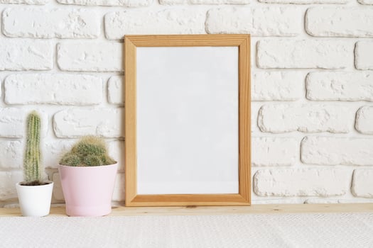 Square wooden photo frame and cactus plants on the table