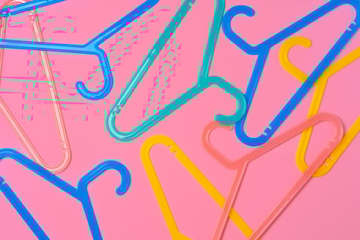 Flat lay composition with empty hangers on pink background photo