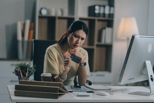 Unhappy and dissatisfied young Asian female office employee contacts a credit card call-center service to inform them of the problems. photo