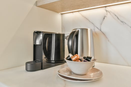 A coffee maker and a cup on a counter photo