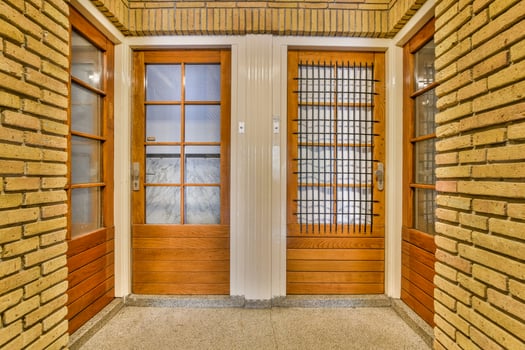 A hallway with two doors and a brick wall photo