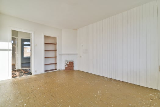 An empty room with a wooden floor and white walls photo