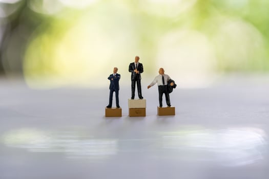 Miniature businessmen stand on white background together. Business leader, teamwork photo