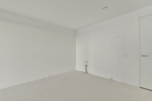 An empty room with white walls and a door photo