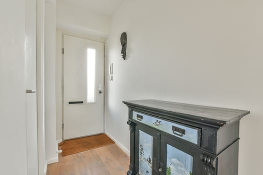 A hallway with a cabinet and a door photo