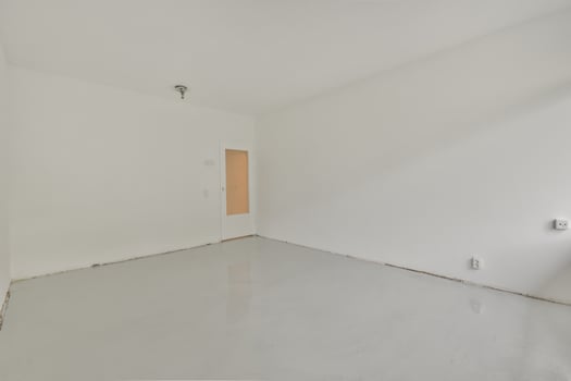 An empty room with white walls and a white floor photo