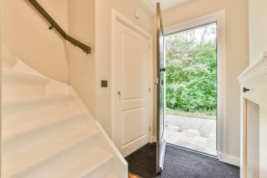 A white door with a white door handle and a white staircase photo