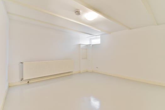An empty room with white walls and a radiator photo