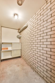 A white brick wall with a shelf and a light fixture photo