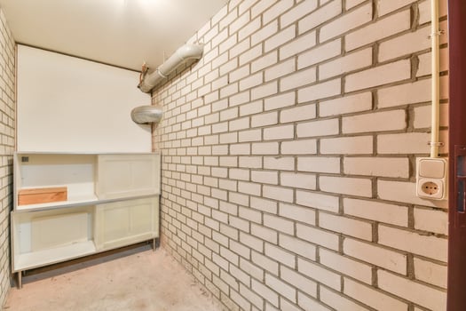 A small room with a brick wall and shelves photo