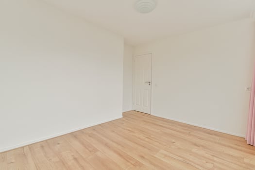 Empty room with wooden floors and pink curtains photo