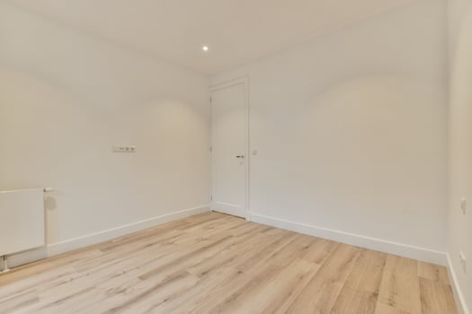 An empty room with wooden floors and white walls photo