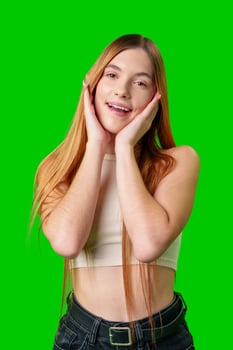 Young Woman With Long Red Hair Smiles in Front of Green Screen photo