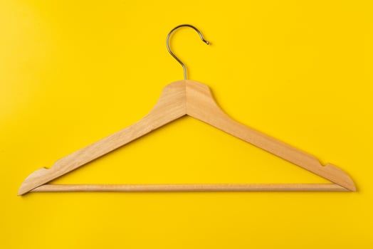 Hanger on colored paper background. Minimalistic fashion concept. photo