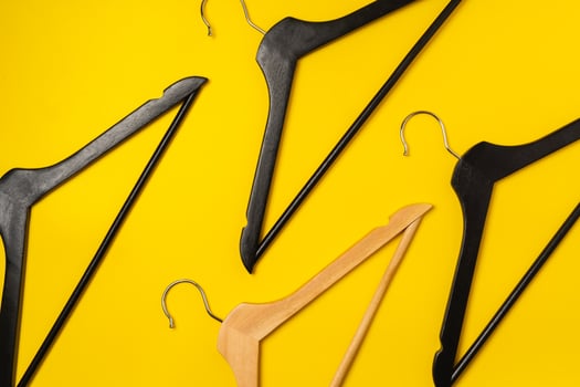 Hanger on colored paper background. Minimalistic fashion concept. photo