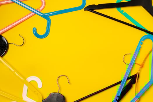 Hanger on colored paper background. Minimalistic fashion concept. photo