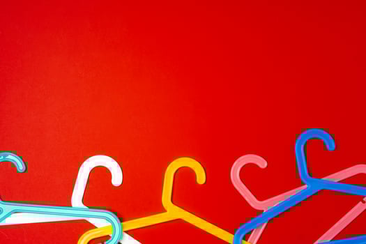 Hanger on red paper background. Minimalistic fashion concept. Top view photo