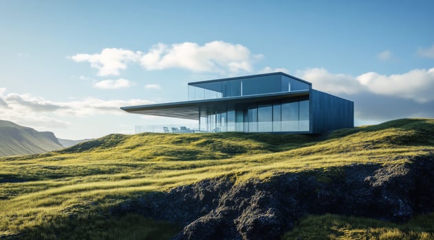 Modern architectural house on a green hillside under a clear blue sky at sunset photo