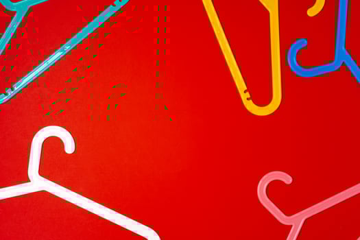 Hanger on red paper background. Minimalistic fashion concept. Top view photo