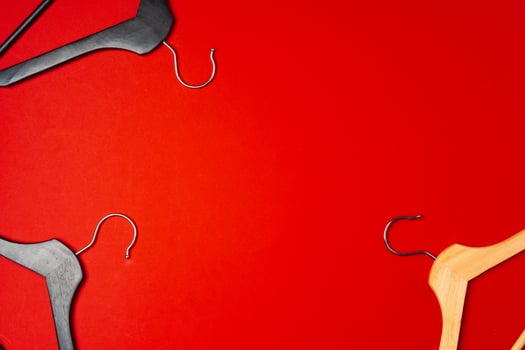 Hanger on red paper background. Minimalistic fashion concept. Top view photo