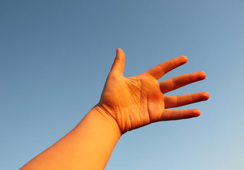 Woman's hand on blue sky background photo