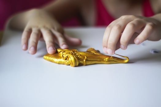 Child playing with a gold slime photo