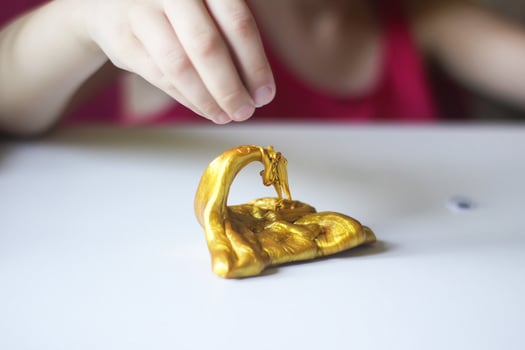 Child playing with a gold slime photo
