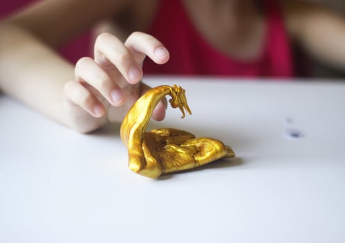 Child playing with a gold slime photo