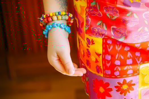 Handmade bright beads on a child's body in sunlight. photo