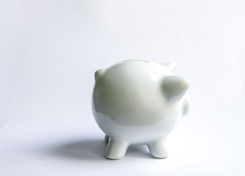 Piggy bank with coins. White ceramic moneybox. photo