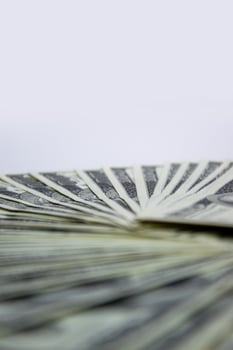 A close-up shot of several US dollar bills arranged in a fan shape, with a white background photo