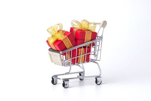 Supermarket trolley, cart with red gifts with gold bows, shopping isolated on white background. Discounts, Sale, Black Friday. photo