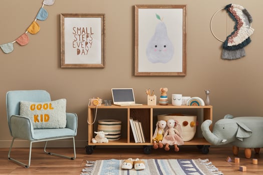 Stylish scandinavian kid room interior with toys, teddy bear, plush toys, mint armchair, furniture, decoration and child accessories. Brown wooden mock up poster frames on the wall. photo