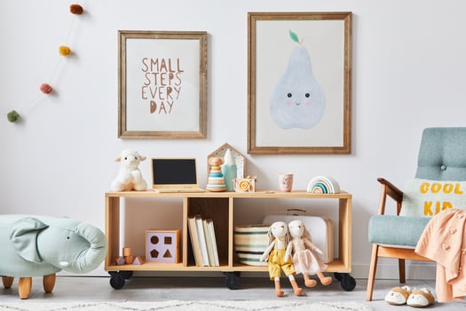 Cozy interior of child room with mint armchair, brown mock up poster frames, toys, teddy bear, dolls, plush animal, decoration. White wall. Warm kid space. photo