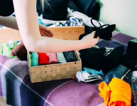 Young woman sorting clothes for donation photo