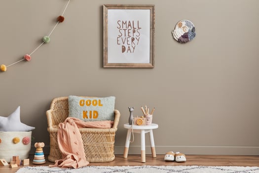 Stylish scandinavian kid room interior with toys, teddy bear, plush animal toys, rattan sofa, furniture, decoration and child accessories. Brown wooden mock up poster frame on the wall. photo