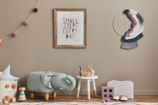 Stylish scandinavian kid room interior with toys, elephant pouf, toys, furniture, decoration and child accessories. Brown wooden mock up poster frames on the wall. photo