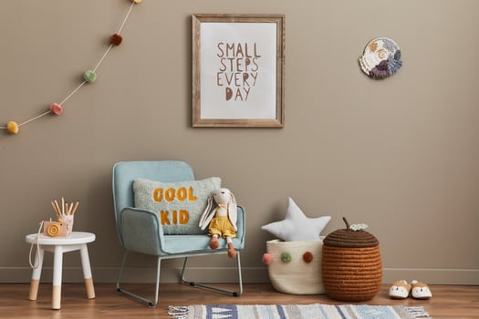 Stylish scandinavian kid room interior with toys, teddy bear, plush animal toys, mint armchair, decoration and child accessories. Brown wooden mock up poster frame on the wall. photo